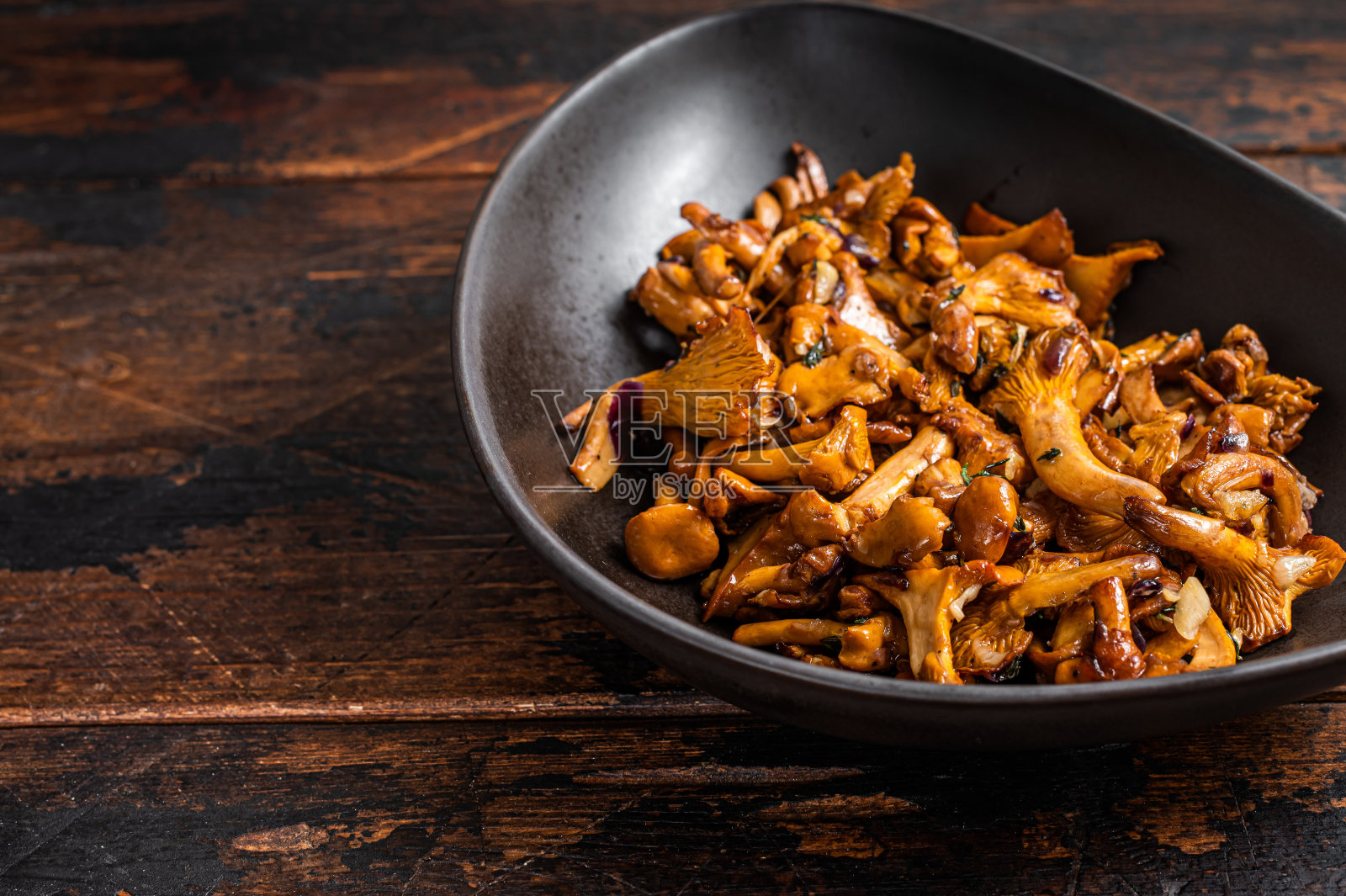 香草炒森林鸡油菌。木制背景。前视图。本空间照片摄影图片