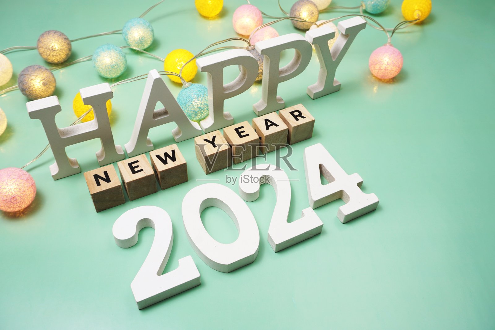 新年快乐2024字母与绿色背景的LED棉花球照片摄影图片