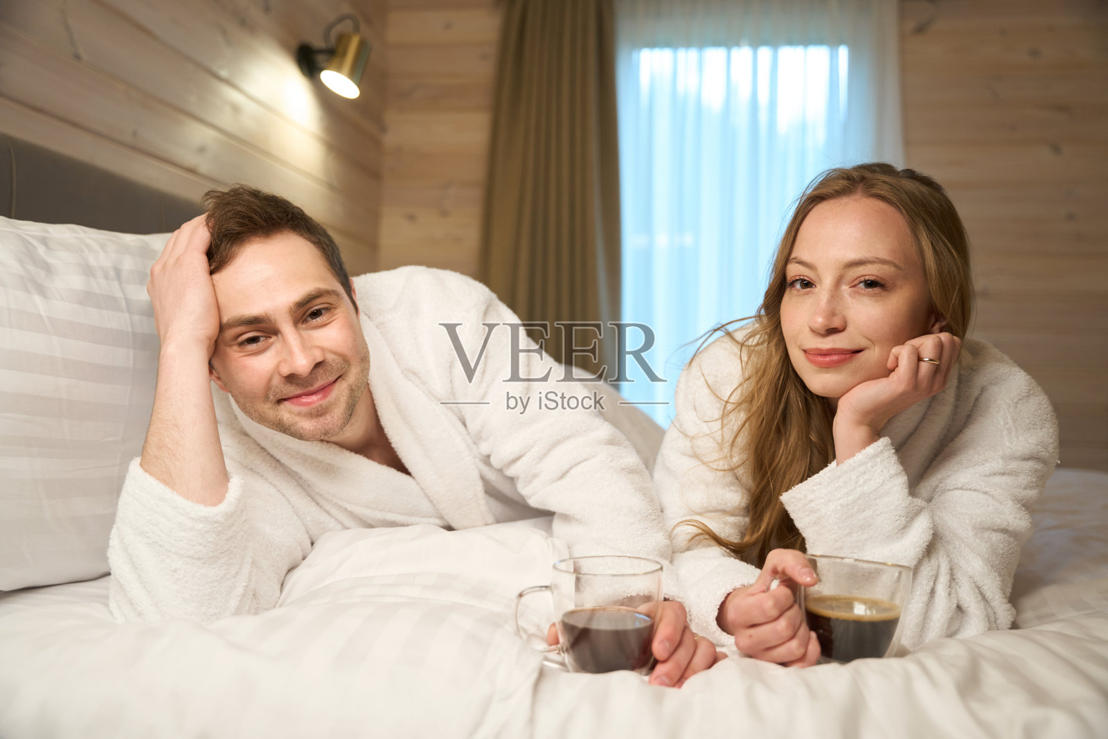 美丽的新婚夫妇躺在床上享受蜜月照片摄影图片