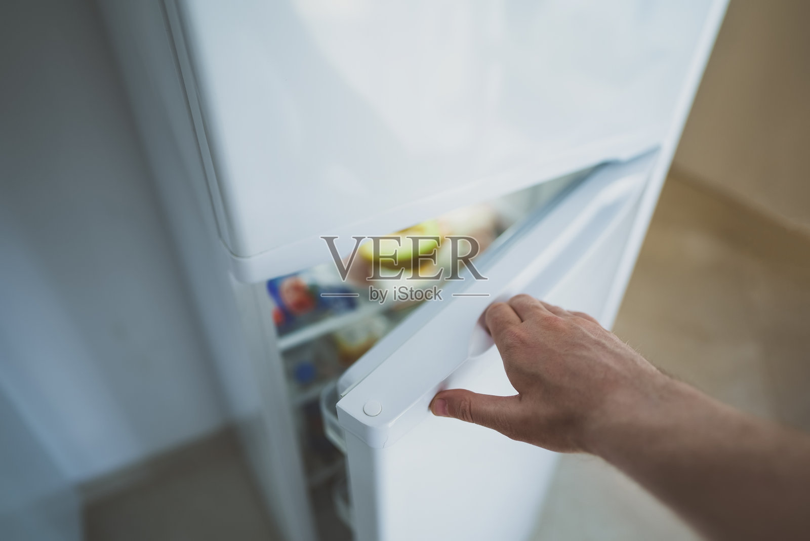 男子打开装有食物的冰箱门。照片摄影图片