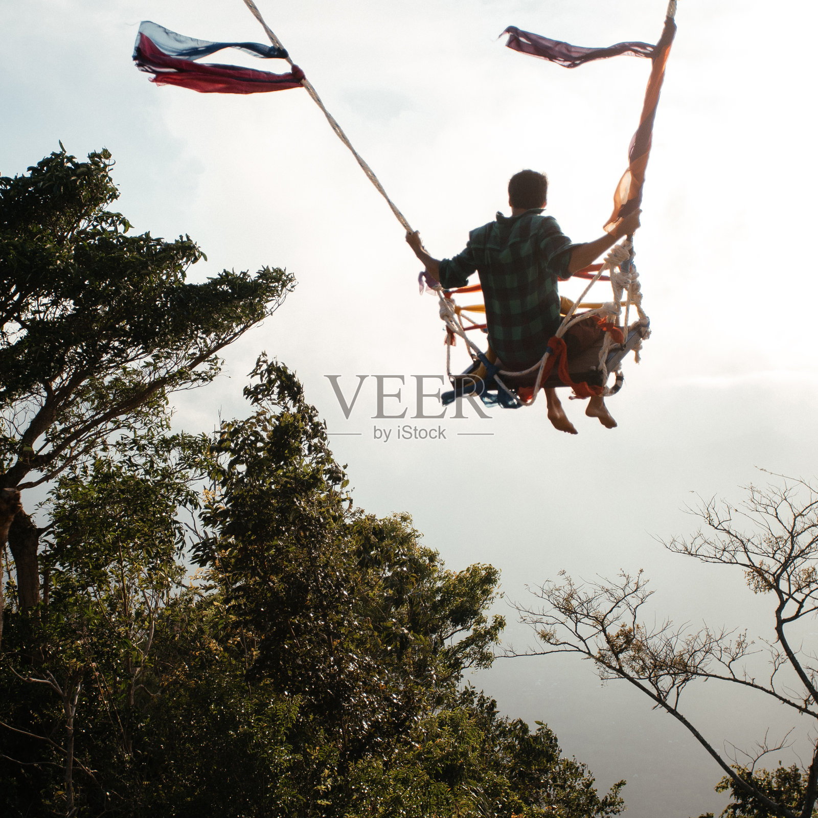 一个人在世界的尽头荡秋千。照片摄影图片
