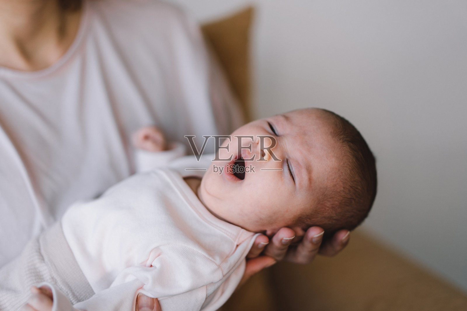 宝宝甜蜜地躺在妈妈的手上。照片摄影图片