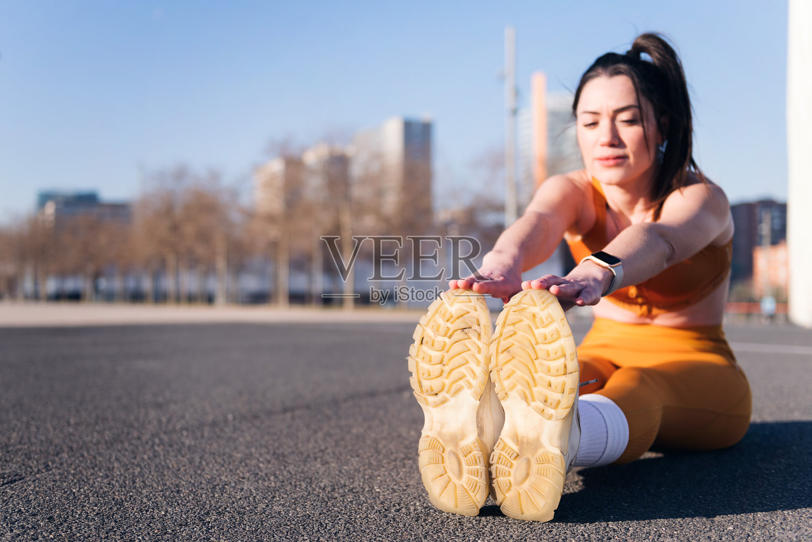 跑步者坐在城市公园里伸展双腿照片摄影图片