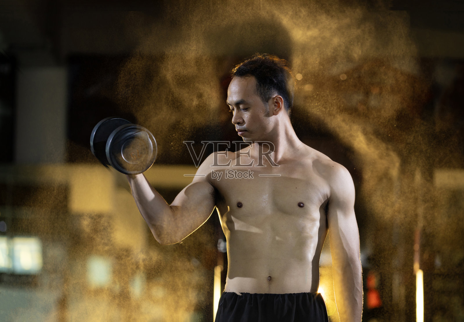 亚洲肌肉的赤膊运动男子练习重量训练哑铃二头肌和三头肌的肌肉在健身房内与黑暗的背景和轻烟光锻炼和锻炼概念照片摄影图片
