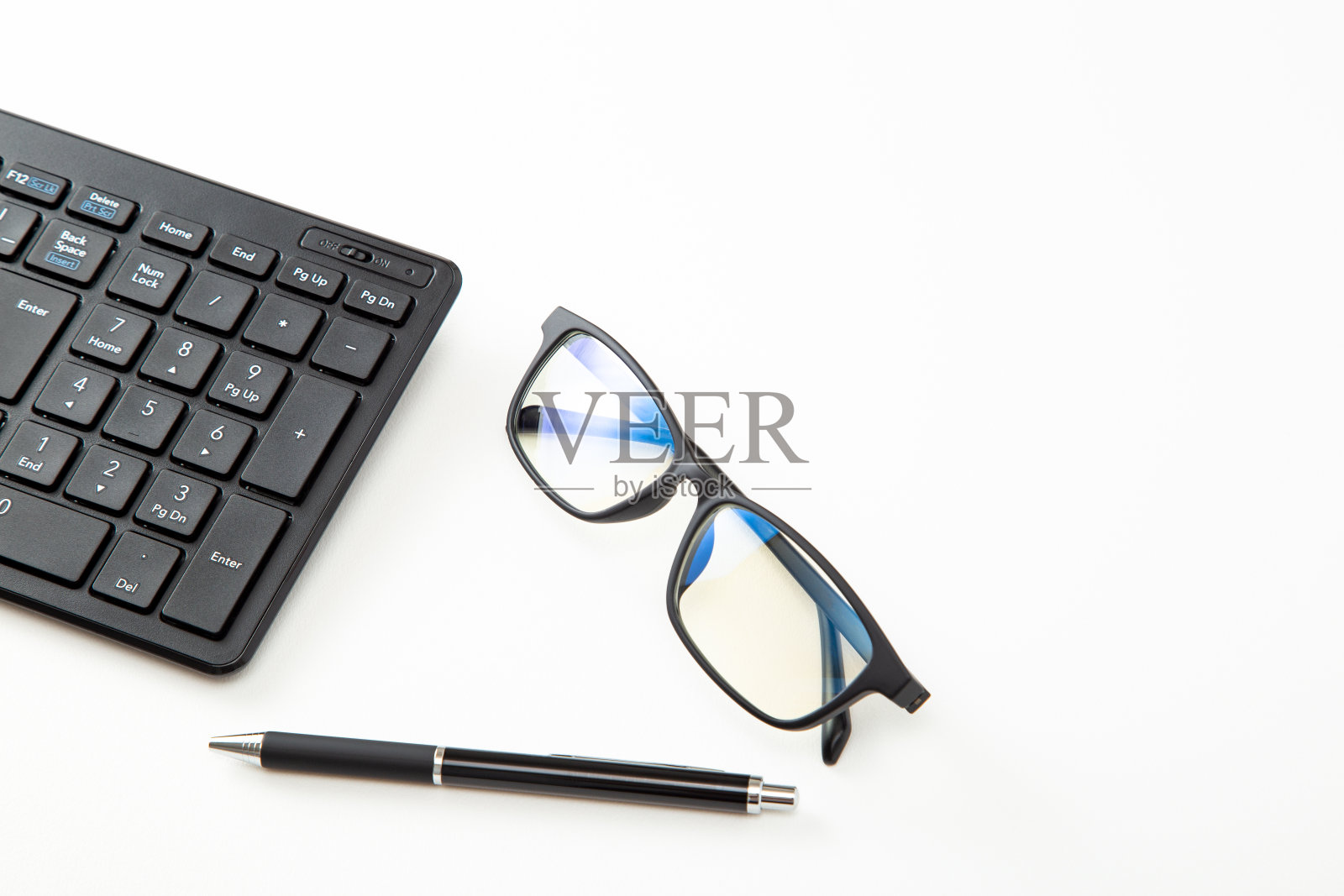 电脑键盘和防蓝光眼镜。照片摄影图片