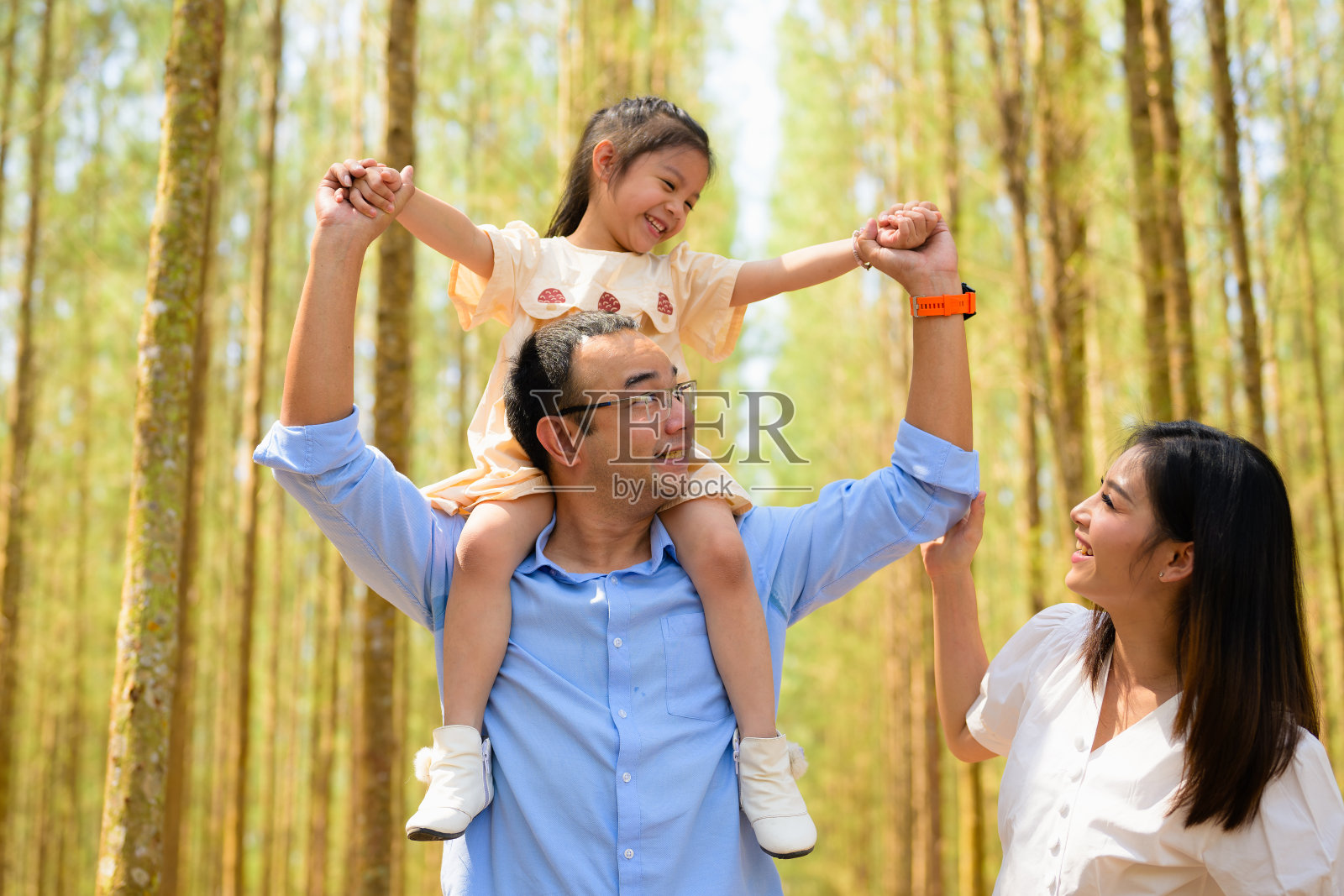 可爱的女孩在假期骑在爸爸的肩膀上一起玩耍照片摄影图片