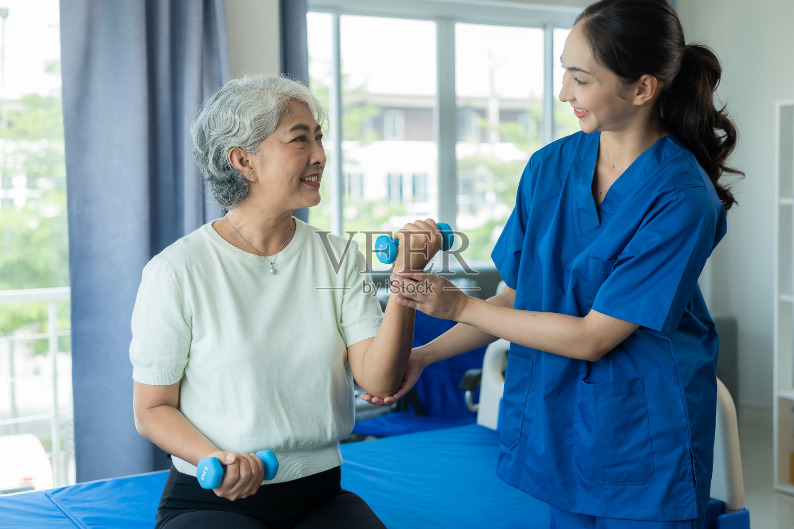 亚洲女性由护士照顾，这些护士跟踪她们的健康状况以及老年女性的肌肉骨骼、肩部和精神物理治疗情况。照片摄影图片