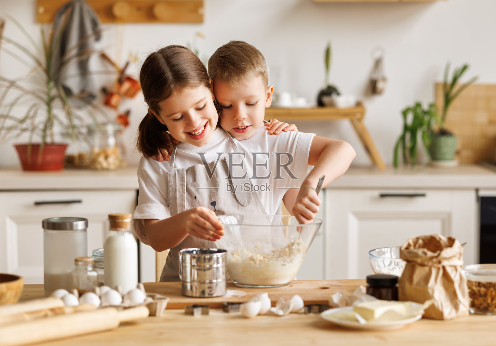 快乐的小朋友兄弟姐妹在厨房里一起揉面做饭照片摄影图片