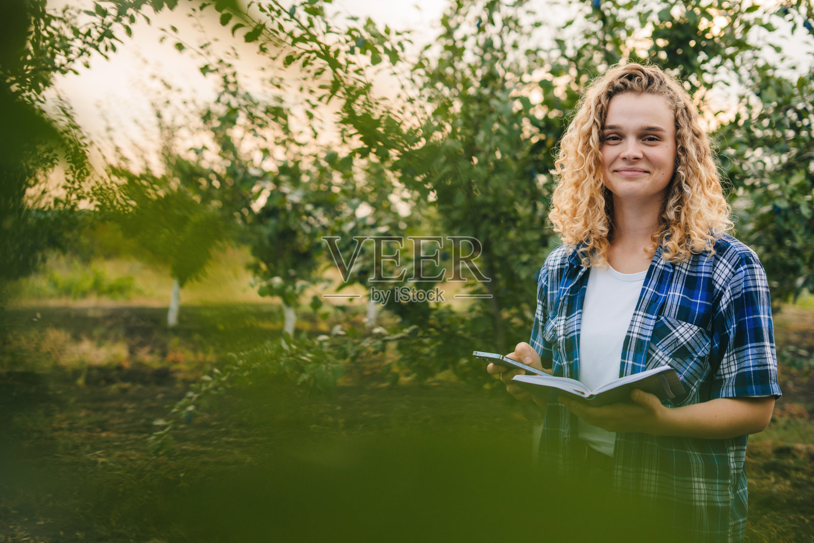 卷发的女人拿着蔬菜种植清单，农业商业发展和肖像。农业、园艺和可持续发展的人，带着作品集接受检查，微笑着看着相机。照片摄影图片
