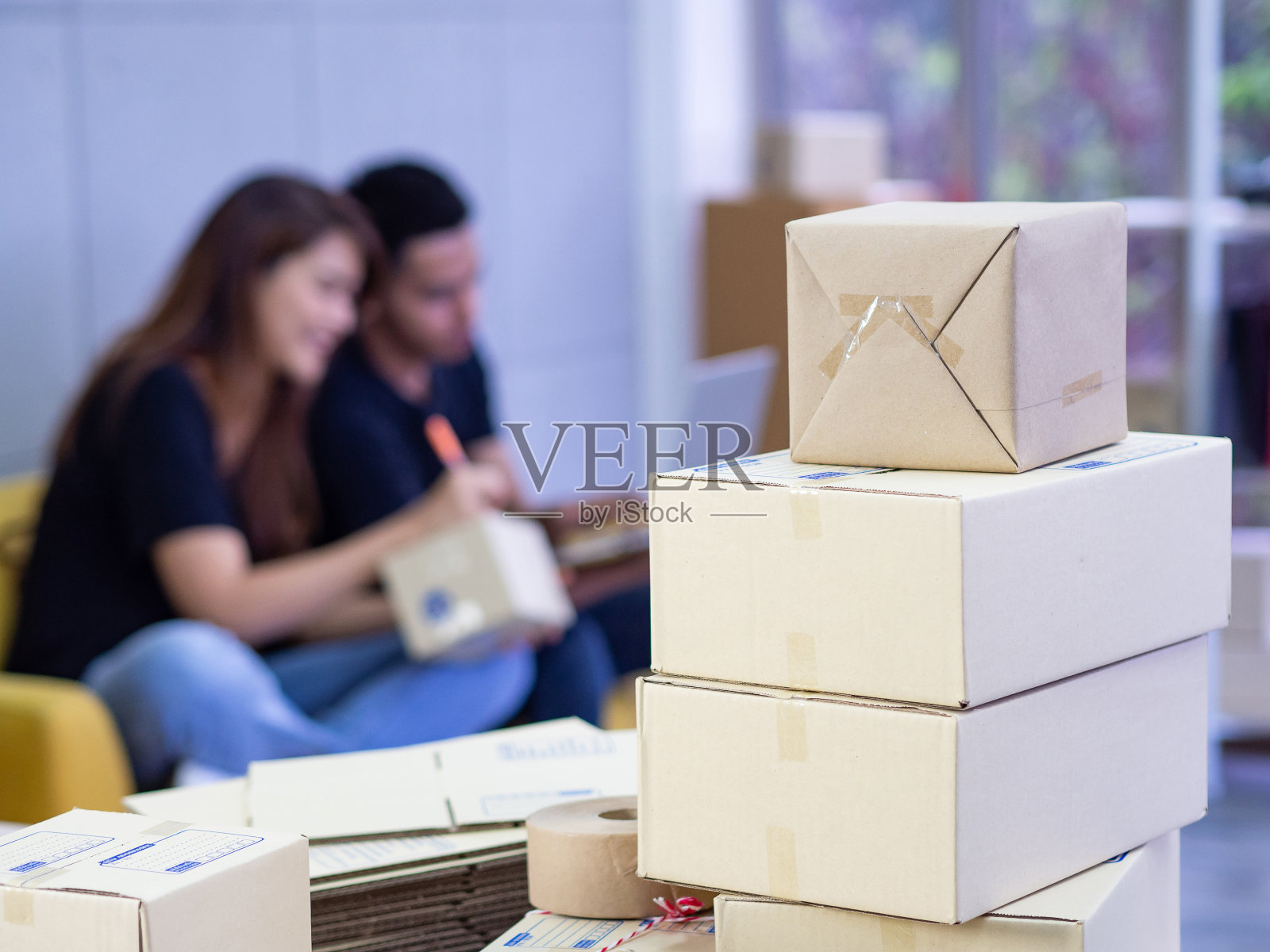 一对年轻的夫妇是电子商务企业家，在办公室里作为一个团队工作。照片摄影图片