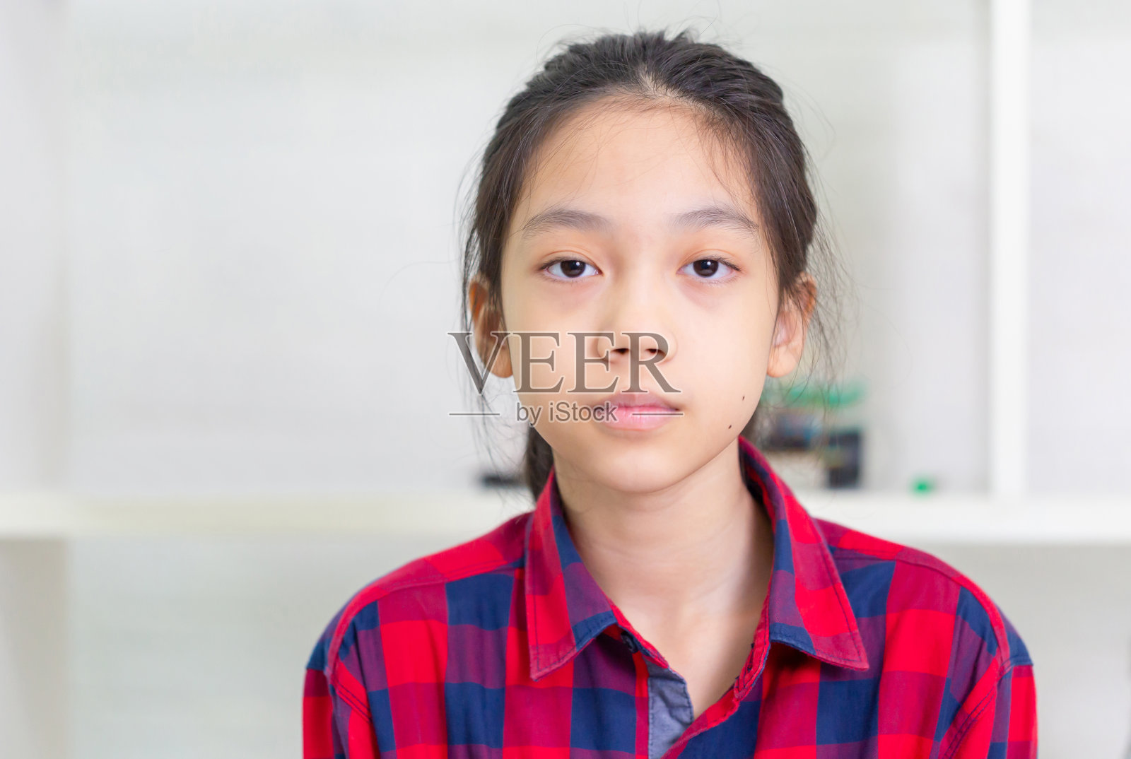 一个小女孩的肖像，孩子在室内摆姿势看相机照片摄影图片