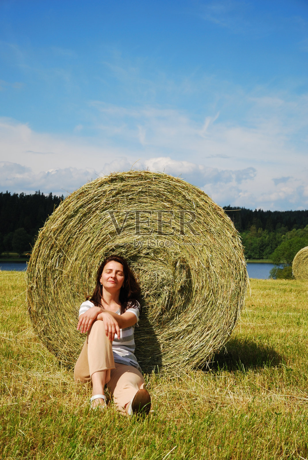 一个女人坐在残茬地里照片摄影图片