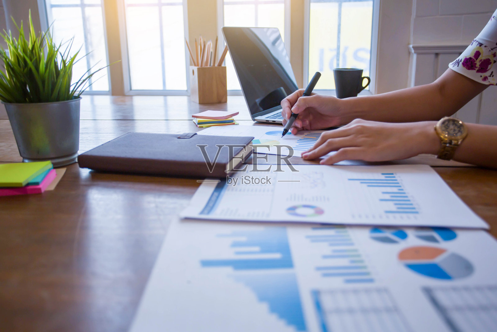 手形象的一个商业妇女工作在早晨温暖的光的电脑笔记本电话和图表的业务分析照片摄影图片