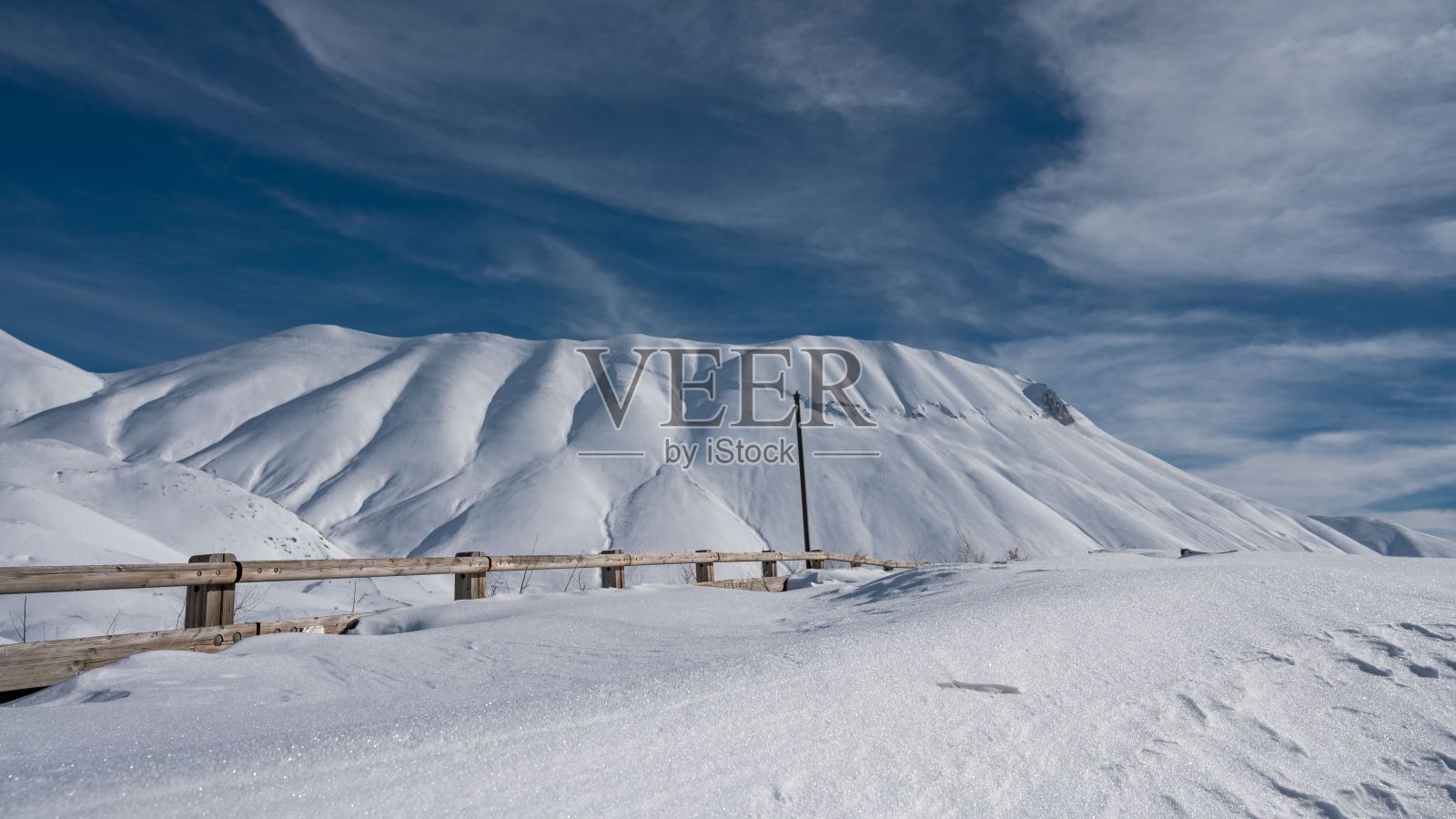 冬季，诺恰城堡(Castelluccio di Norcia)的白色山峰上覆盖着母猪的景观照片摄影图片