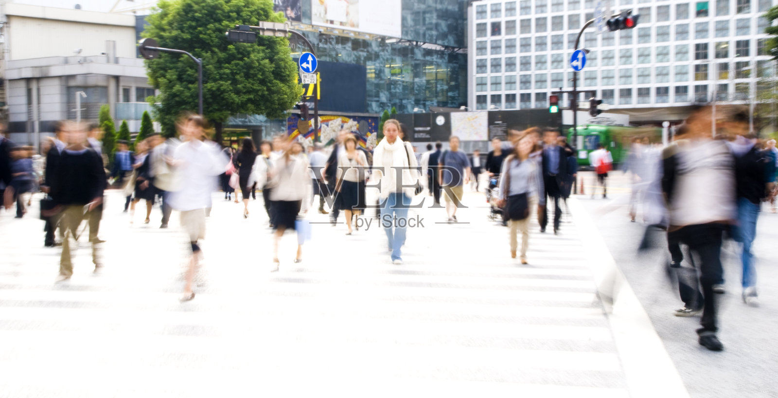 长曝光拍摄的通勤者过马路的白天照片摄影图片
