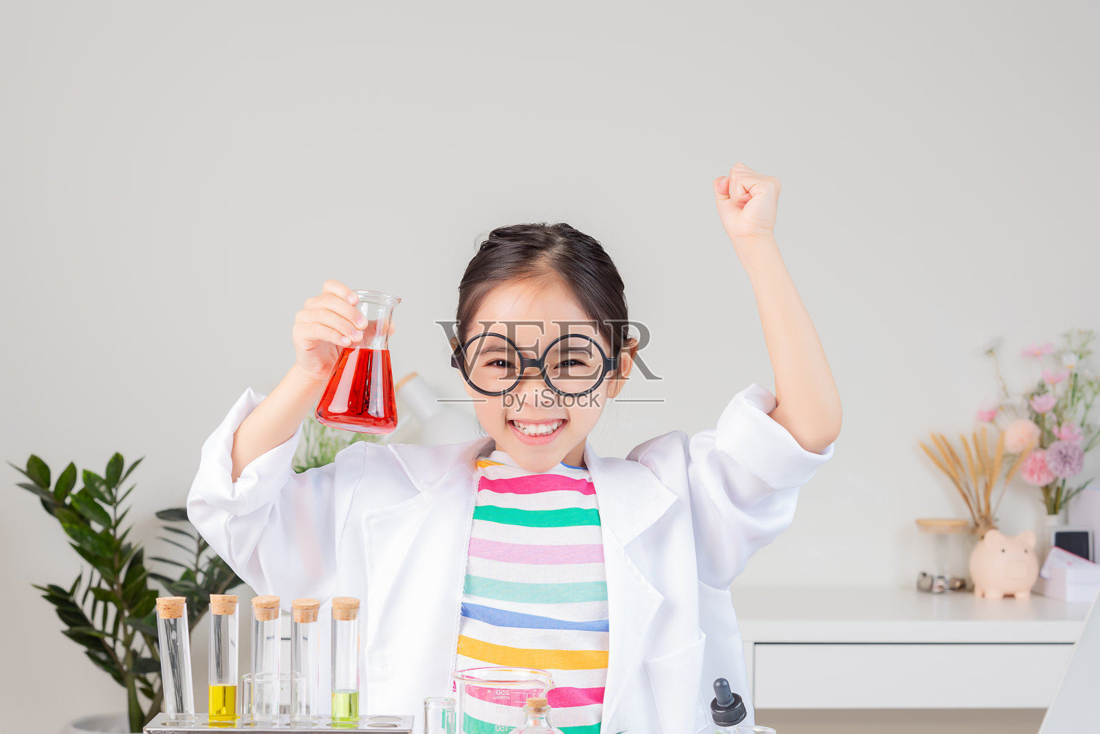 亚裔小女孩在白色教室里做试管科学实验照片摄影图片