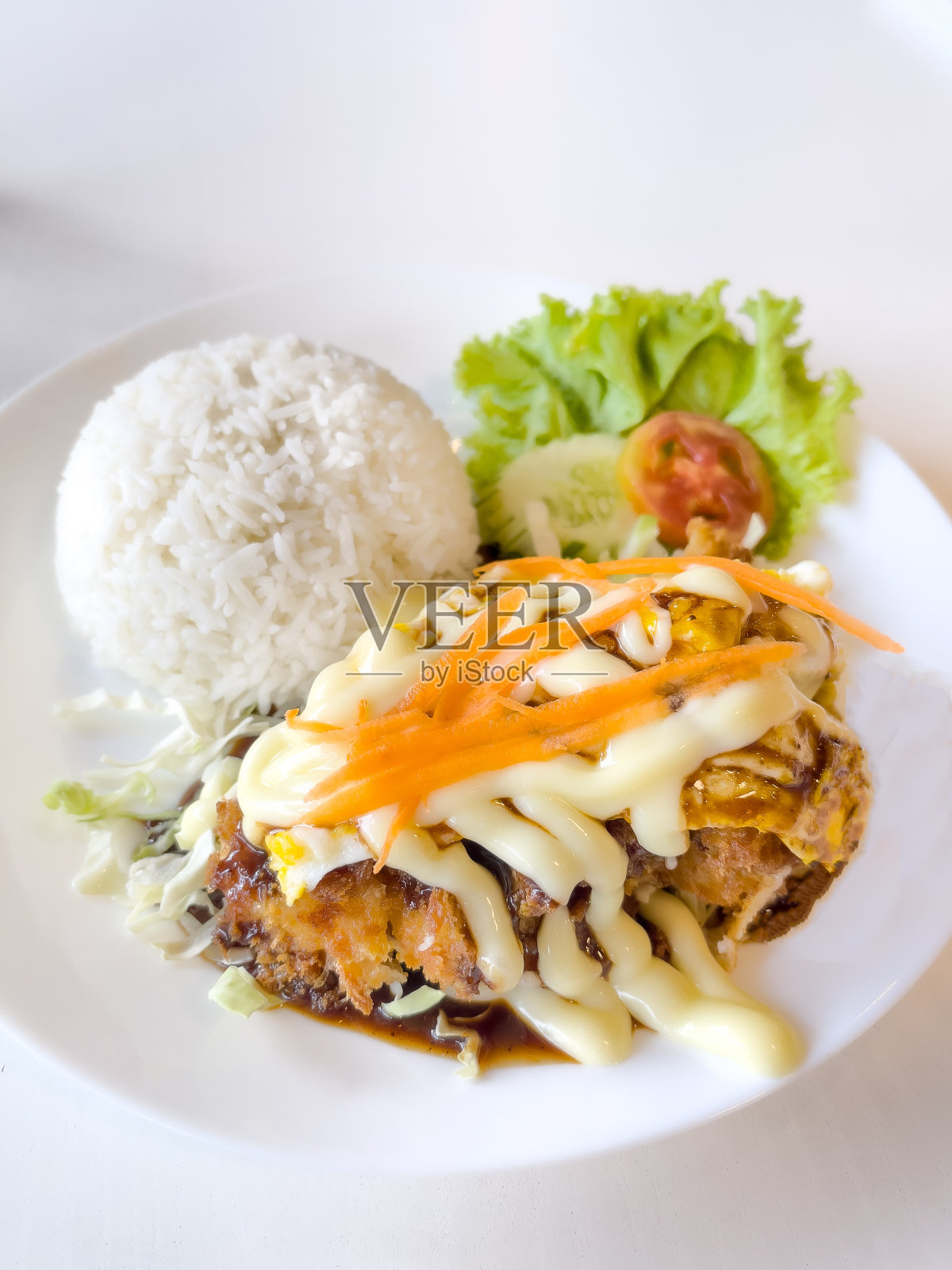 日式料理风格:在餐桌上的白色盘子里放上炒猪肉饭和奶油沙拉。照片摄影图片