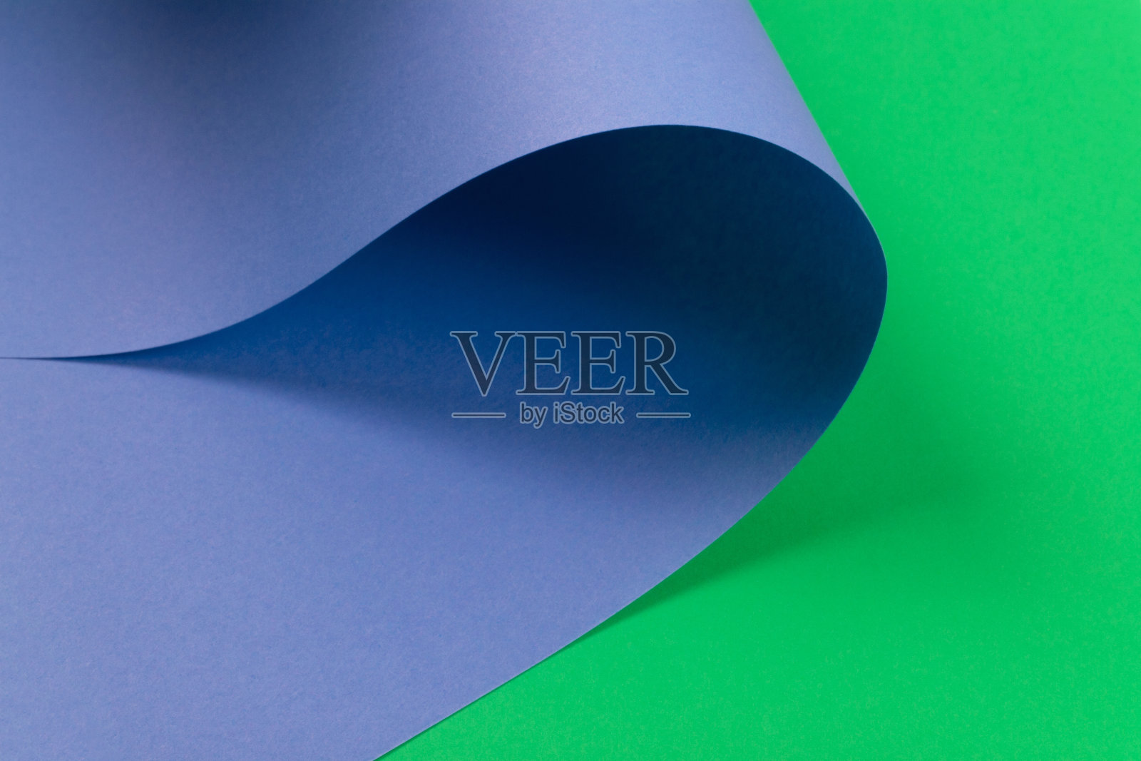 橙色背景上绿色曲线形纸的抽象设计。副本的空间。平的。照片摄影图片