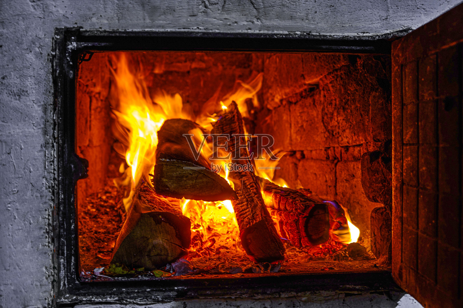 在俄国炉子里烧柴。照片摄影图片