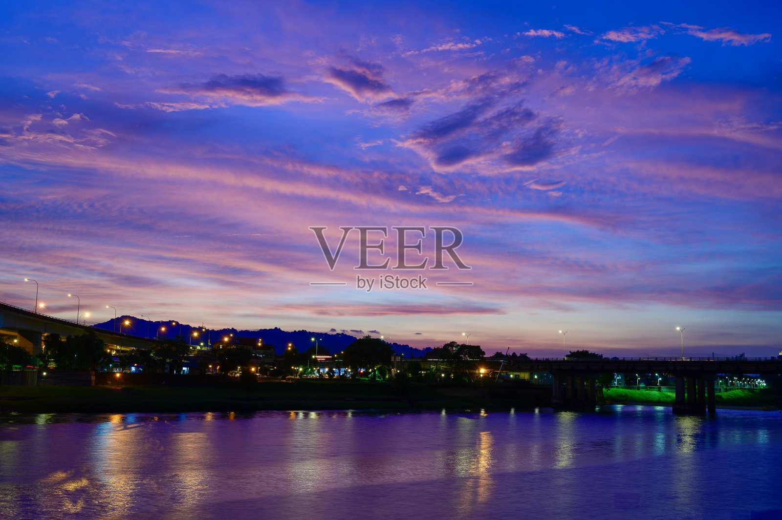 街灯和车灯在湖面上流动和反射。浪漫的夜景。照片摄影图片