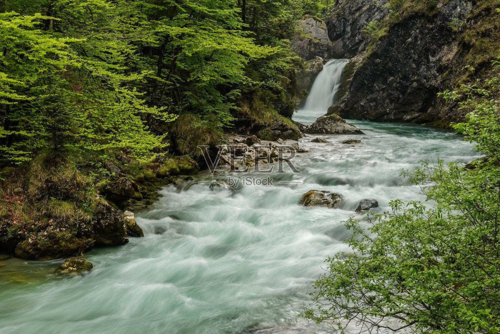 流动的激流与瀑布在岩石绿色的山景观照片摄影图片