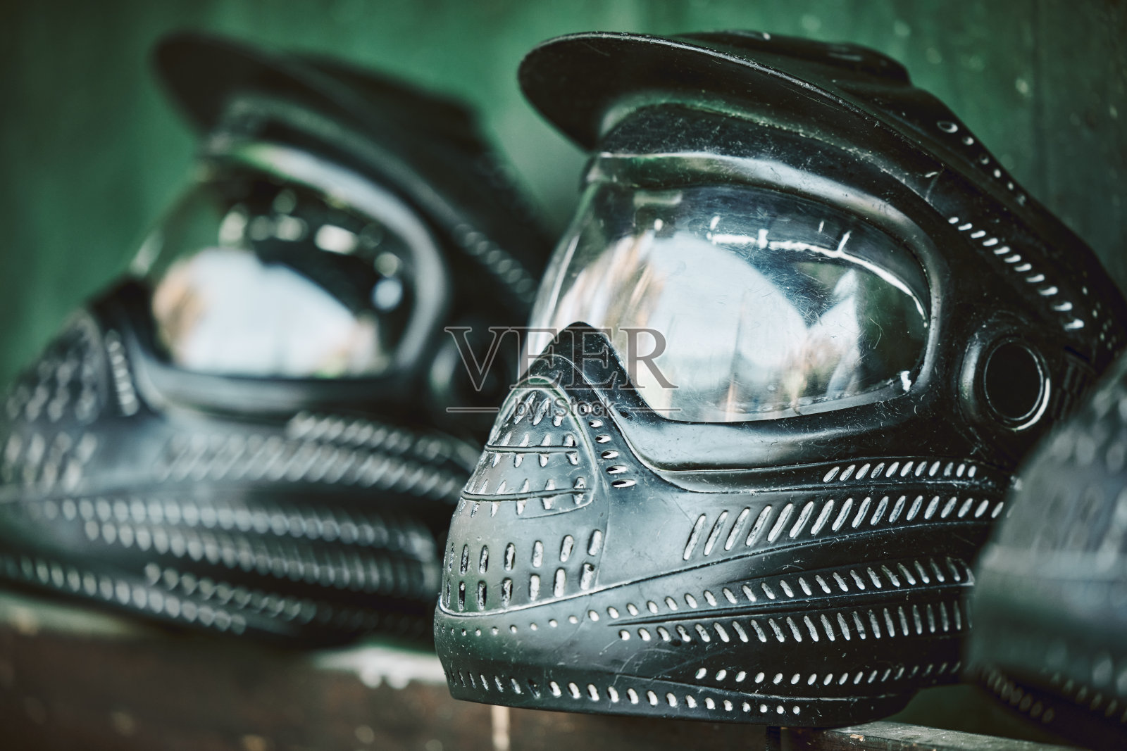 面具，头盔和彩弹与静物设备在户外的桌子上准备战斗训练或战争游戏。安全、运动、军事防护，比赛时佩戴统一头饰照片摄影图片