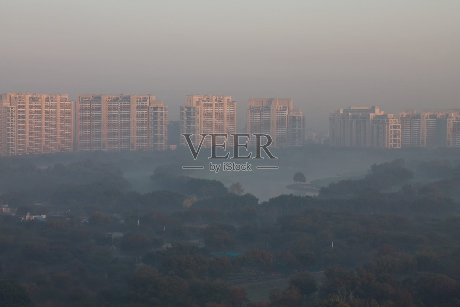 古鲁格拉姆市豪华住宅公寓鸟瞰冬季日出，湖泊被雾包围。照片摄影图片