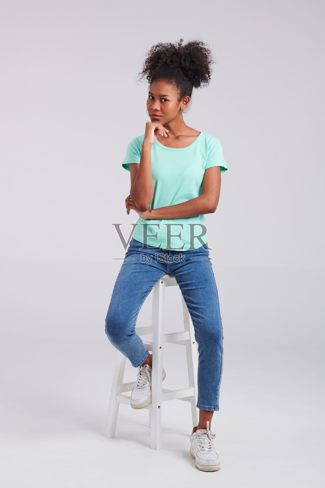 休闲时尚:女性工作室造型薄荷衬衫和蓝色牛仔裤照片摄影图片