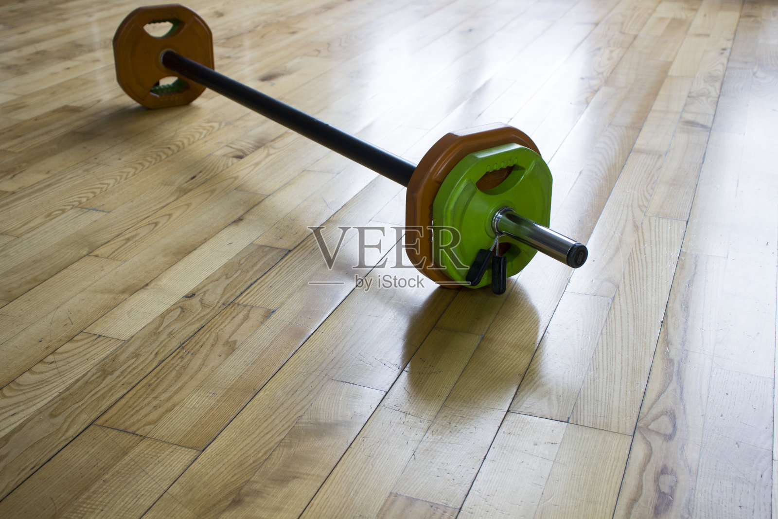 在健身房的木制背景上堆叠杠铃和举重板，复制空间照片摄影图片