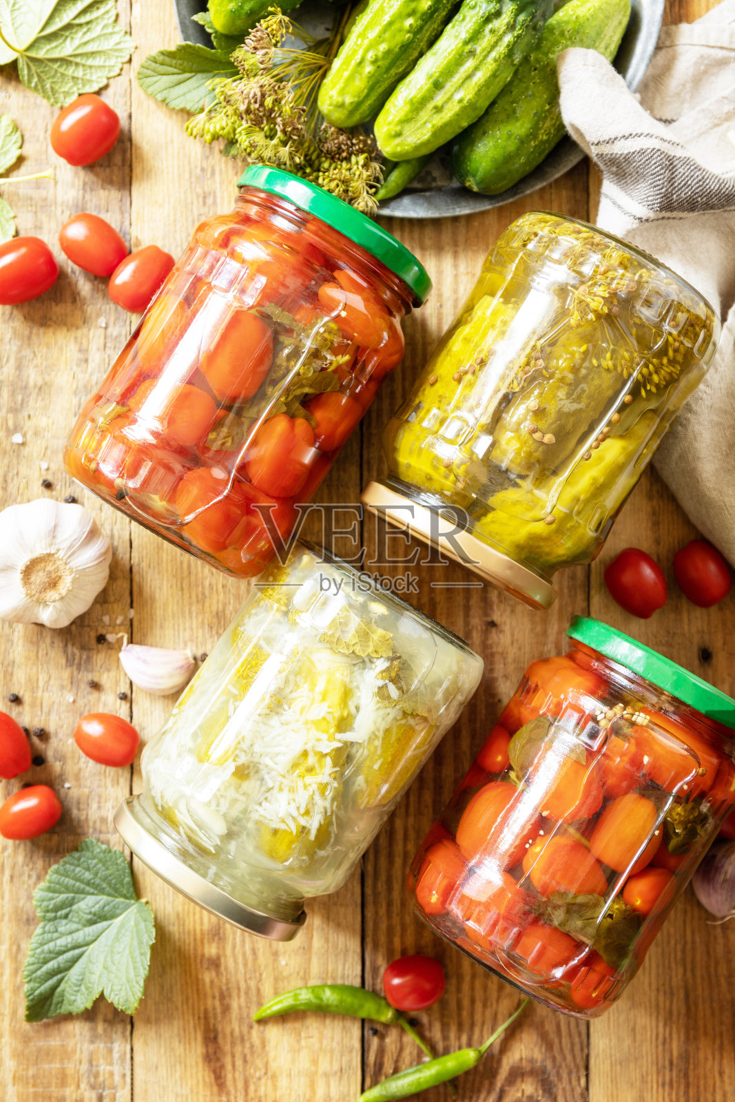 健康的自制发酵食品。玻璃罐腌黄瓜、番茄罐头。家计经济，秋收保鲜。从上面看。照片摄影图片
