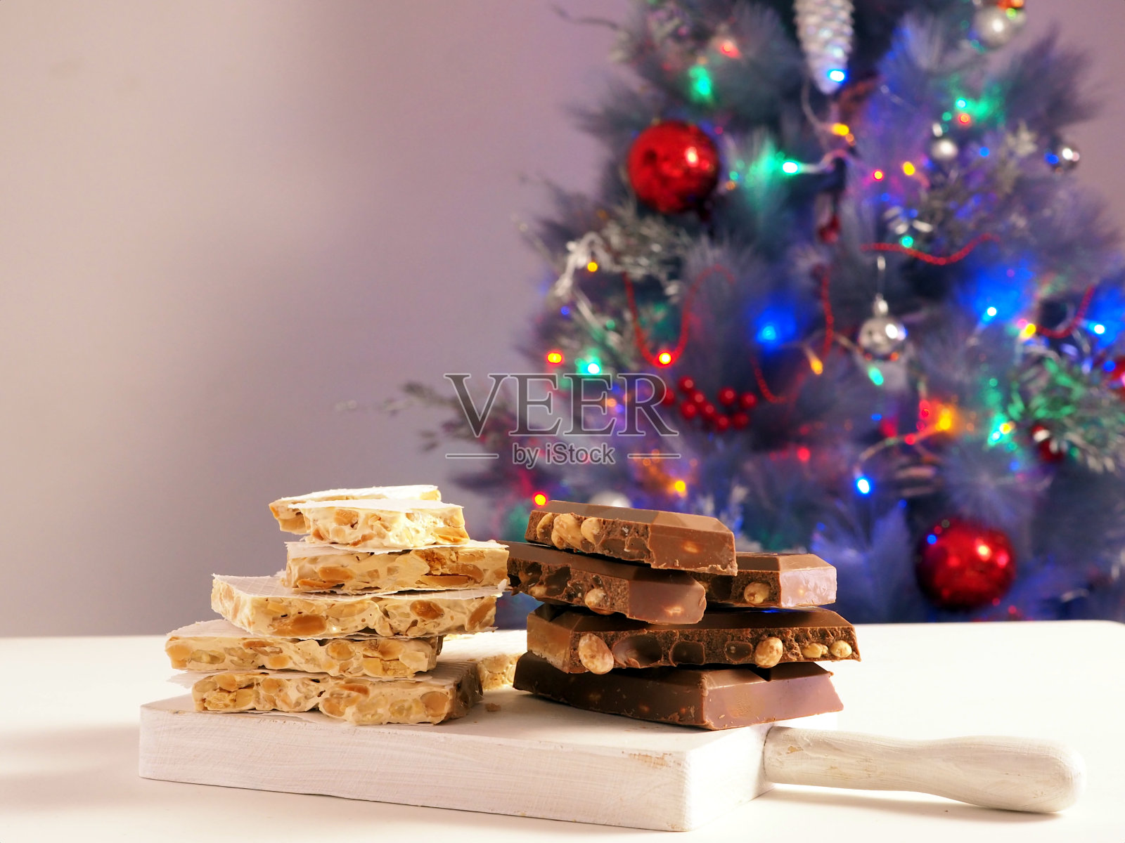 传统的西班牙杏仁甜点- Torrone糖果在圣诞树的背景照片摄影图片
