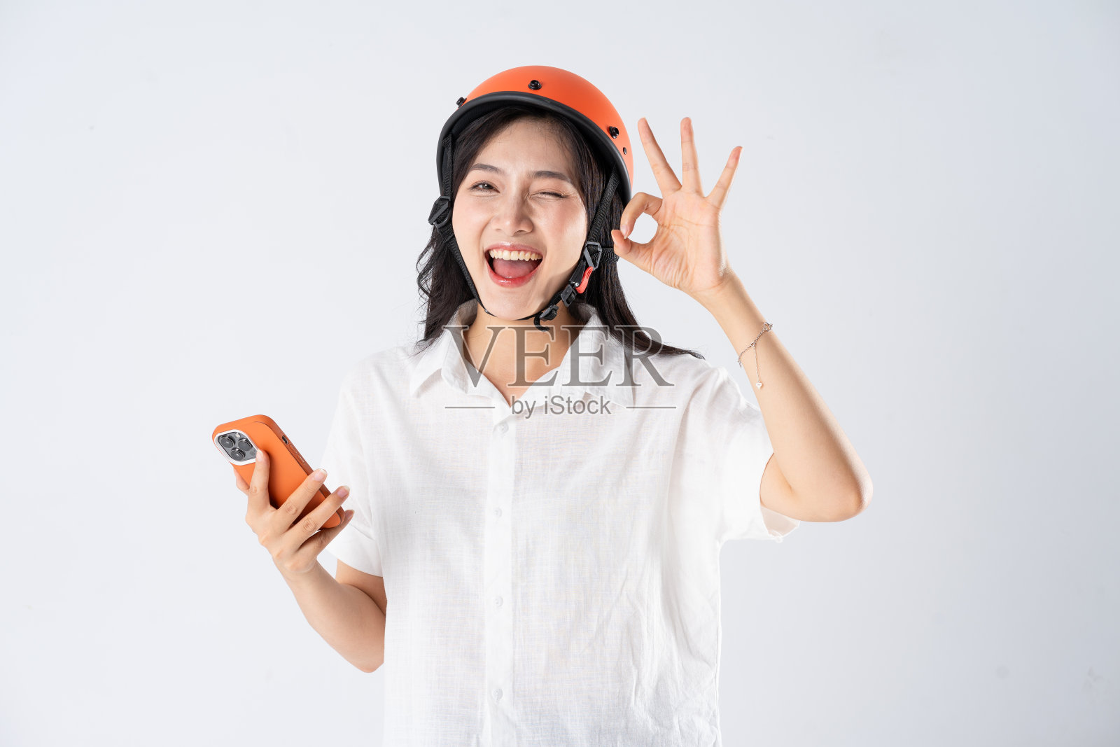 戴着白色背景的橙色头盔的女人照片摄影图片