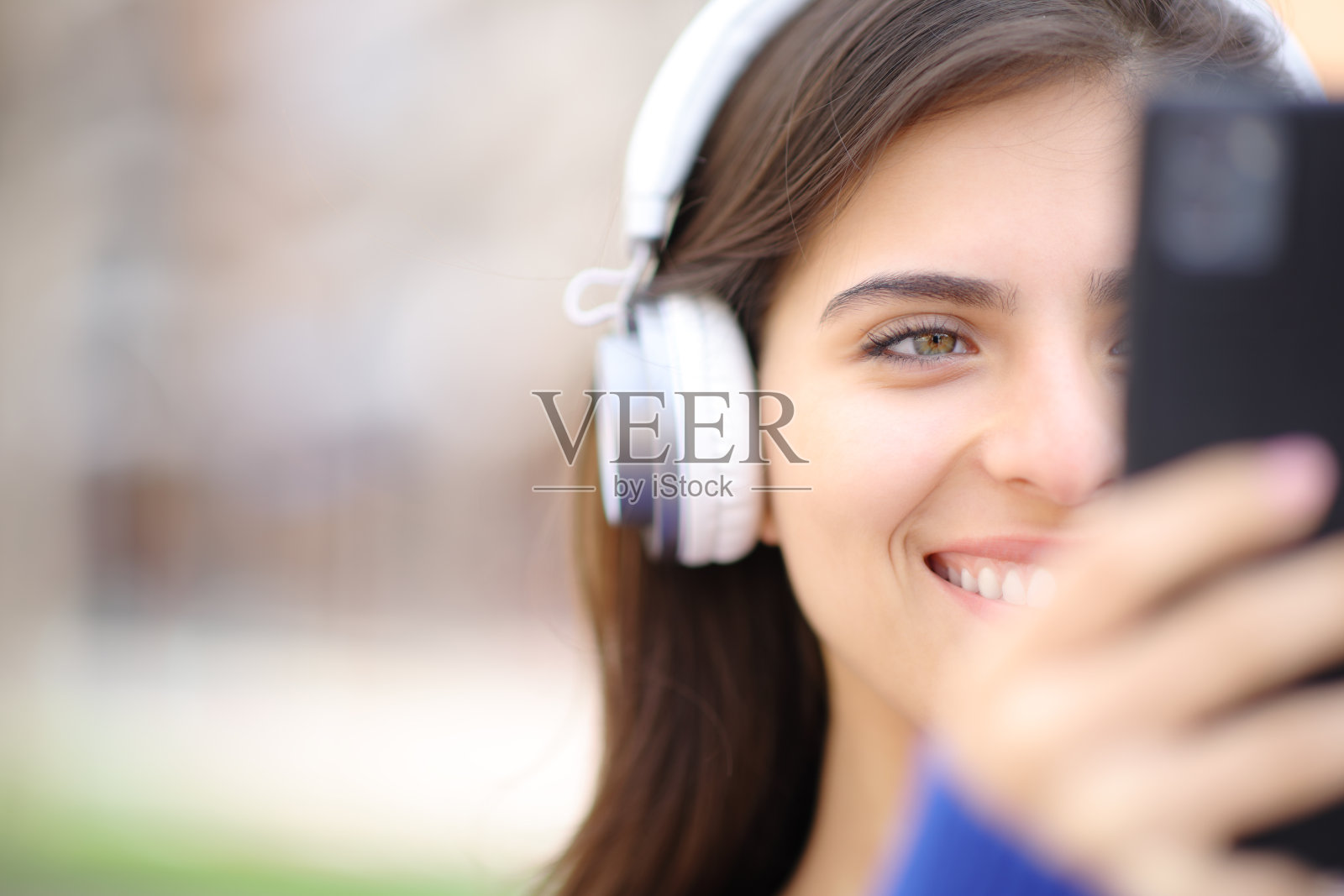 快乐的女人用耳机和智能手机听音频照片摄影图片