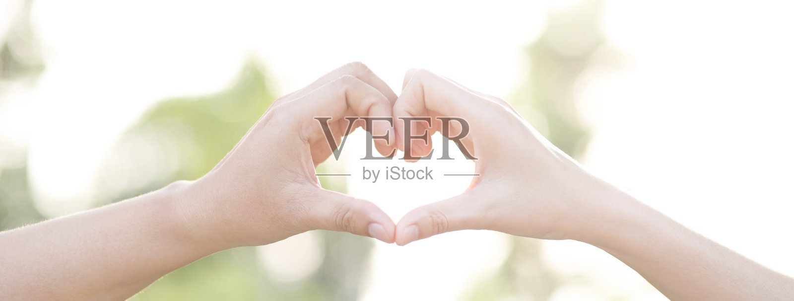 情侣们在公园里浪漫地牵着手朝着灿烂的阳光，或者近距离观看初恋的概念性画面。情人照片摄影图片