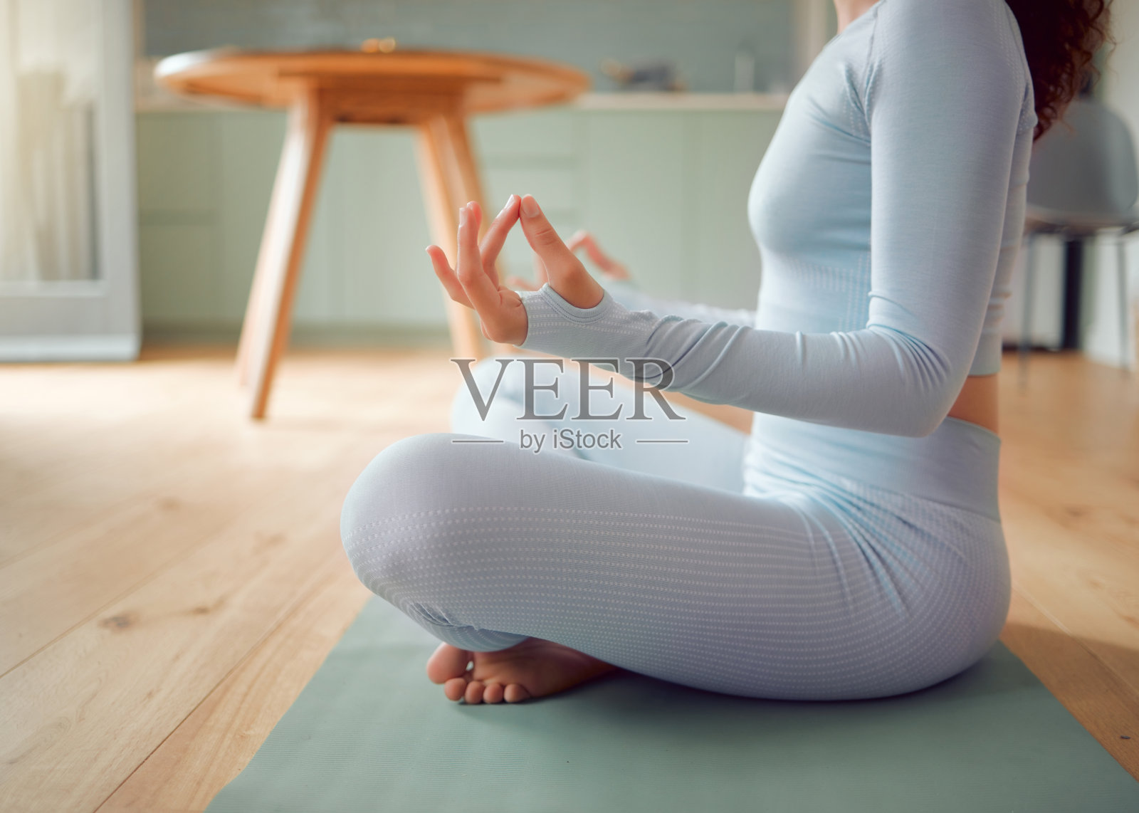 特写年轻的混血女子在冥想体式的位置，而练习瑜伽在家里。不知名的女性锻炼她的身体和思想，寻找内心的和平，平衡和清晰照片摄影图片