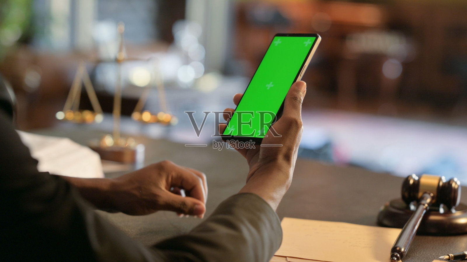 法官在法庭上手持绿屏手机的特写照片摄影图片