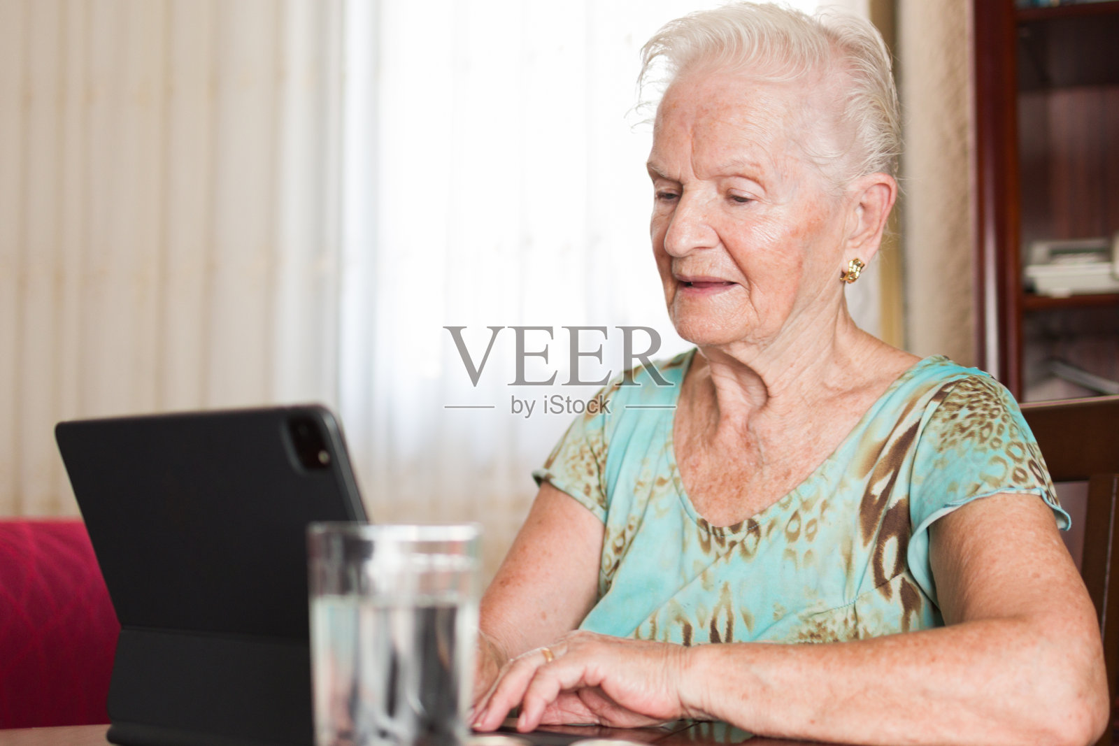 一位白发苍苍的白人老太太在家里用笔记本电脑上网照片摄影图片