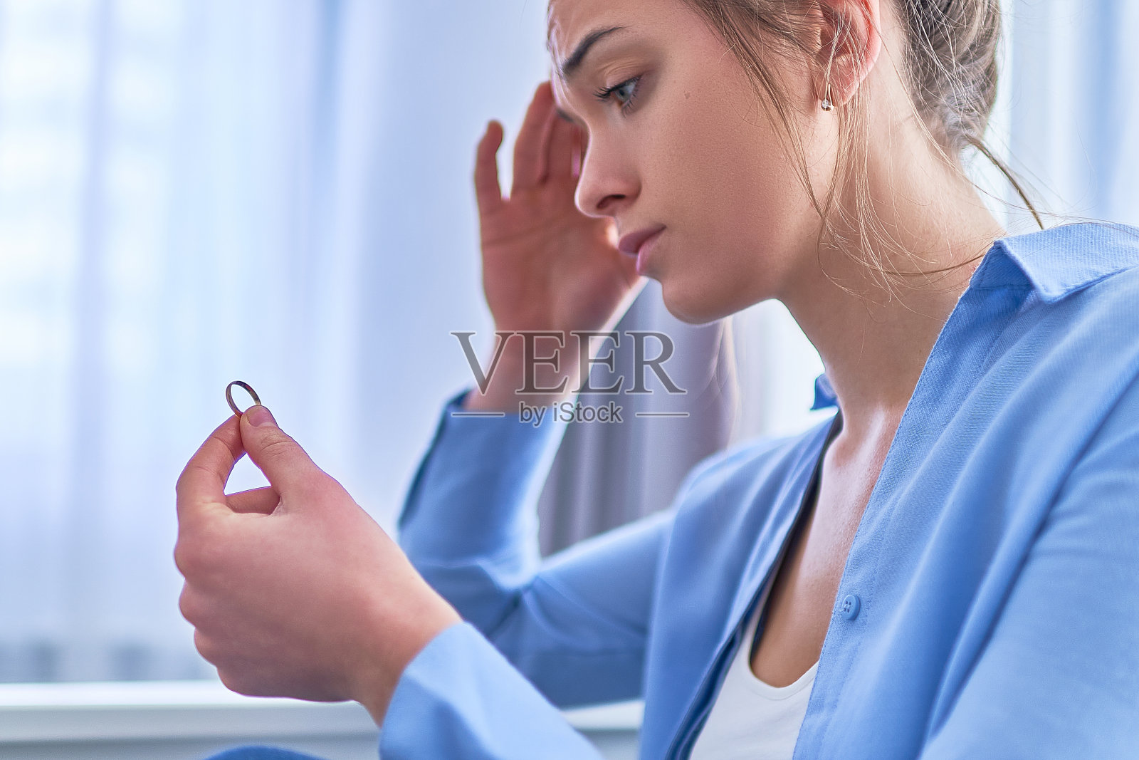 悲伤、不快乐、心烦意乱的女人在与丈夫争吵、人际关系困难和家庭危机中拿着结婚戒指照片摄影图片