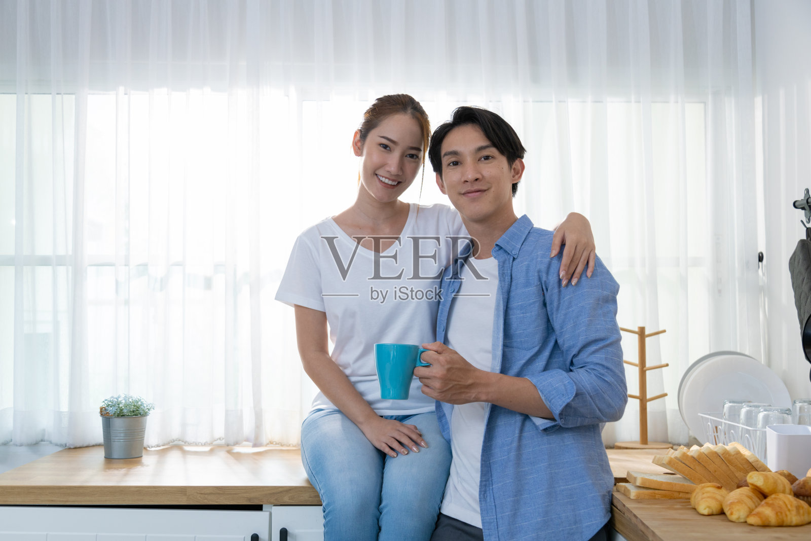 少年夫妇洗涤，烘干，滚筒式烘干，配有全自动洗衣机。照片摄影图片