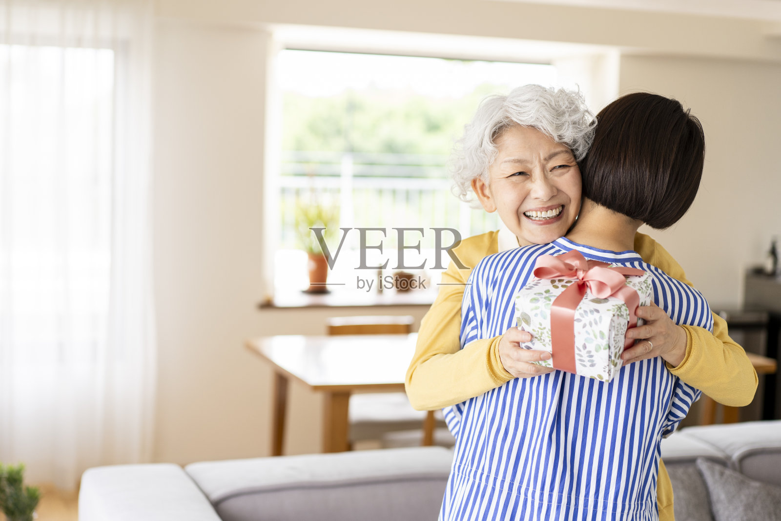 年轻女子给年长的女人送礼物照片摄影图片
