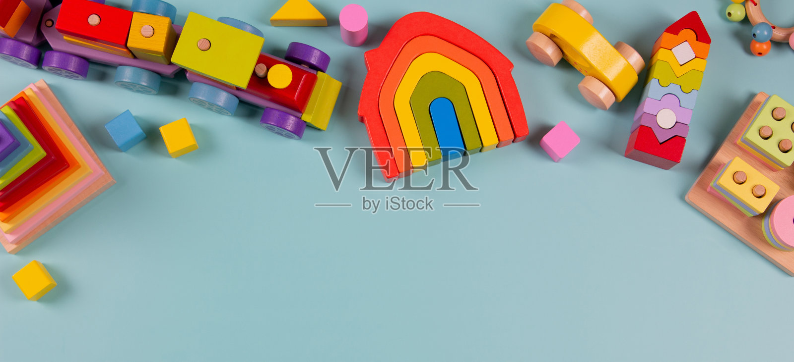 婴儿玩具背景。木制火车，浅蓝色背景的彩色可持续教育玩具。蒙台梭利，环保儿童玩具。俯视图，平铺照片摄影图片