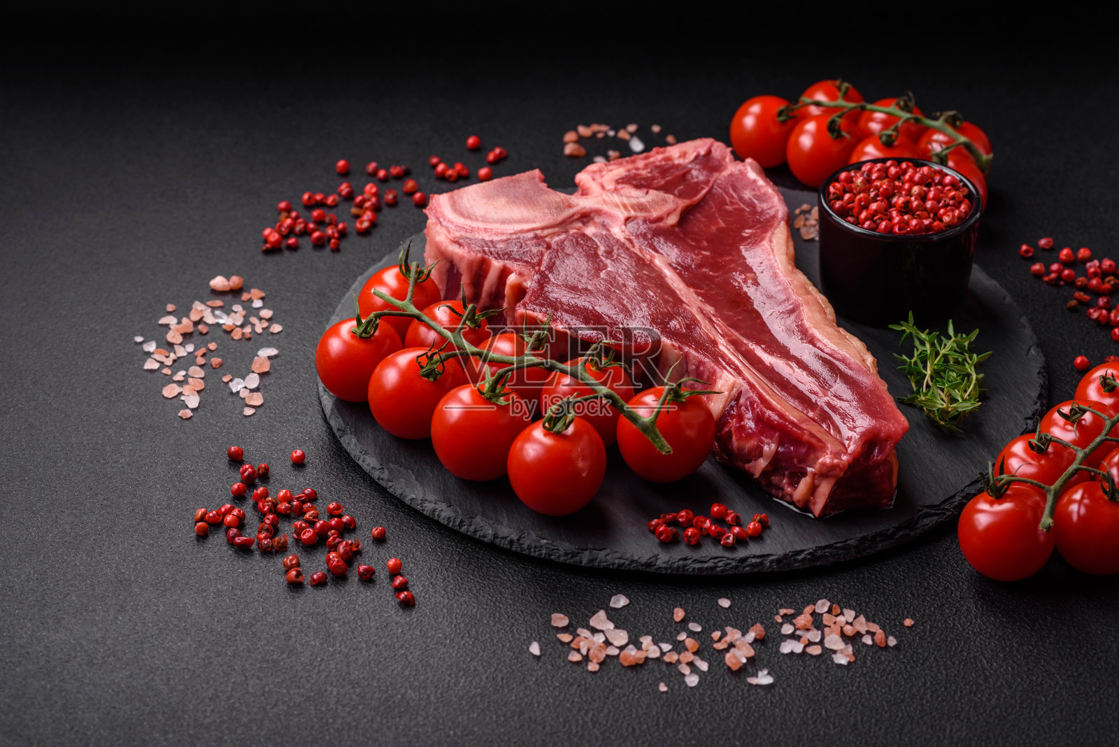 新鲜多汁的牛t骨牛排加盐，香料和香草照片摄影图片