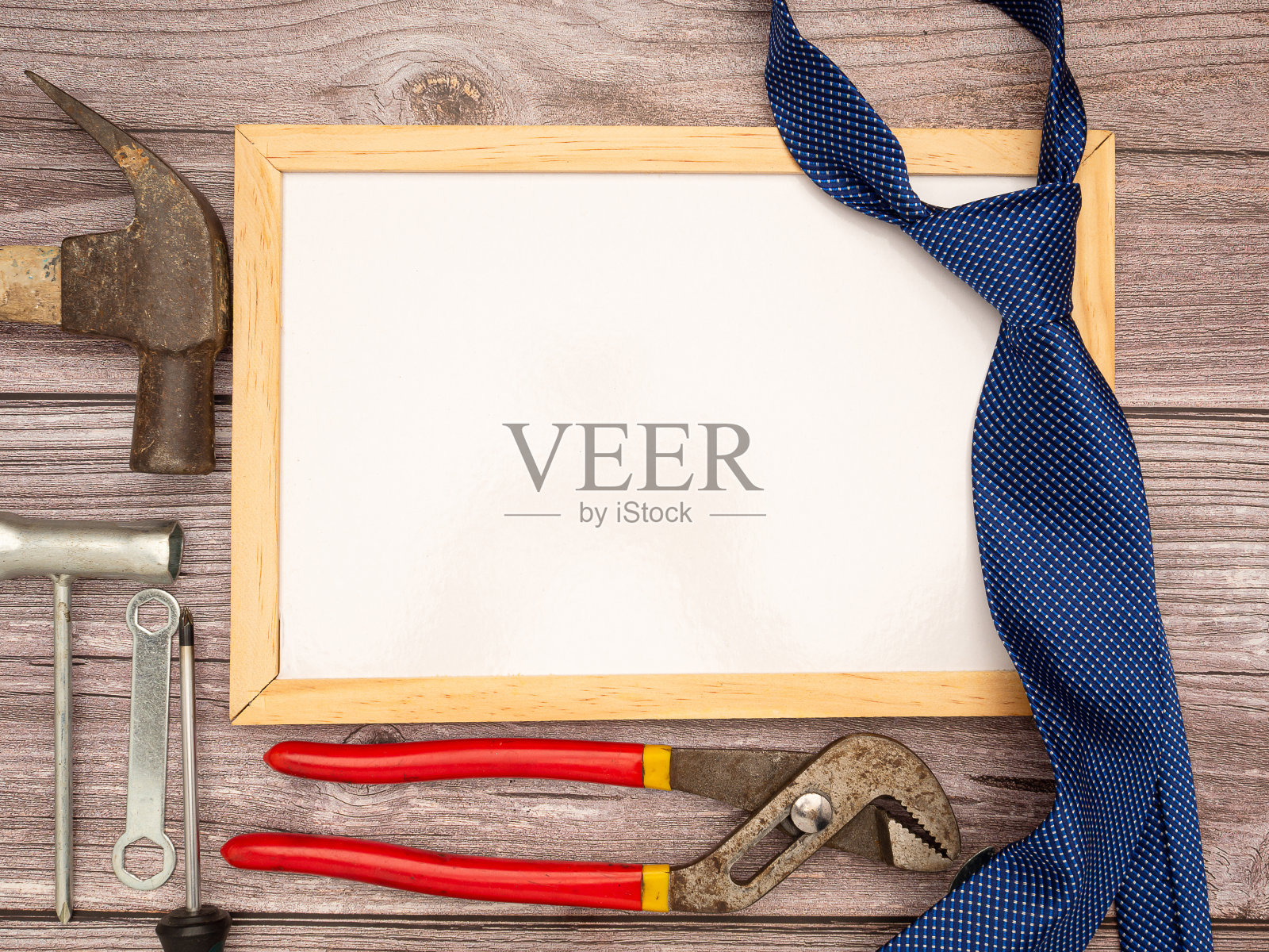 祝您父亲节快乐。木桌上准备好空白的迷你白板、领带、施工工具、锤子、螺丝刀、螺丝、钳子照片摄影图片
