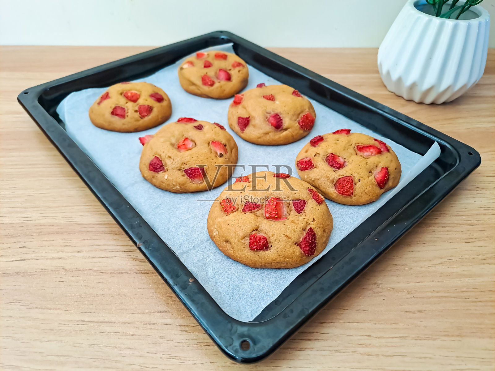 自制的草莓软饼干，放在烤板上，刚从烤箱里拿出来，放在木桌上照片摄影图片