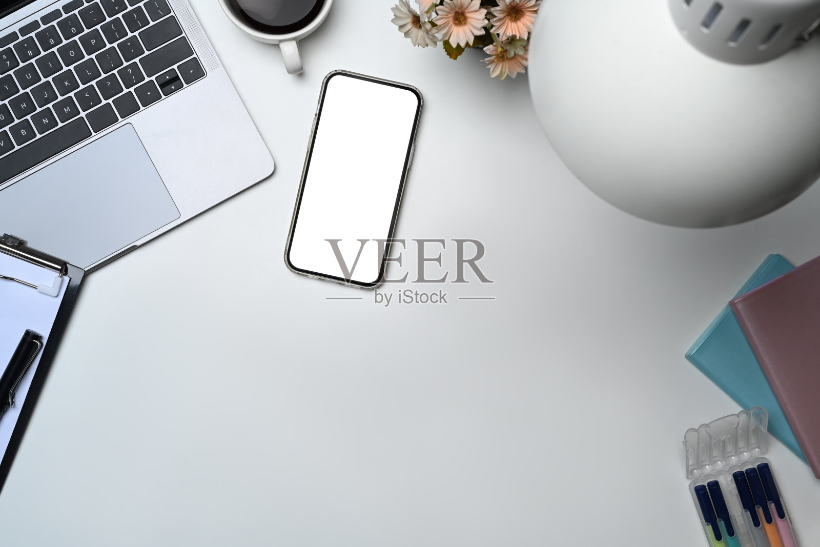 屏幕空的智能手机俯视图，笔记本电脑和白色桌子上的咖啡杯照片摄影图片