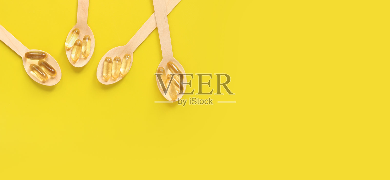 ω- 3。木勺鱼油金胶囊照片摄影图片