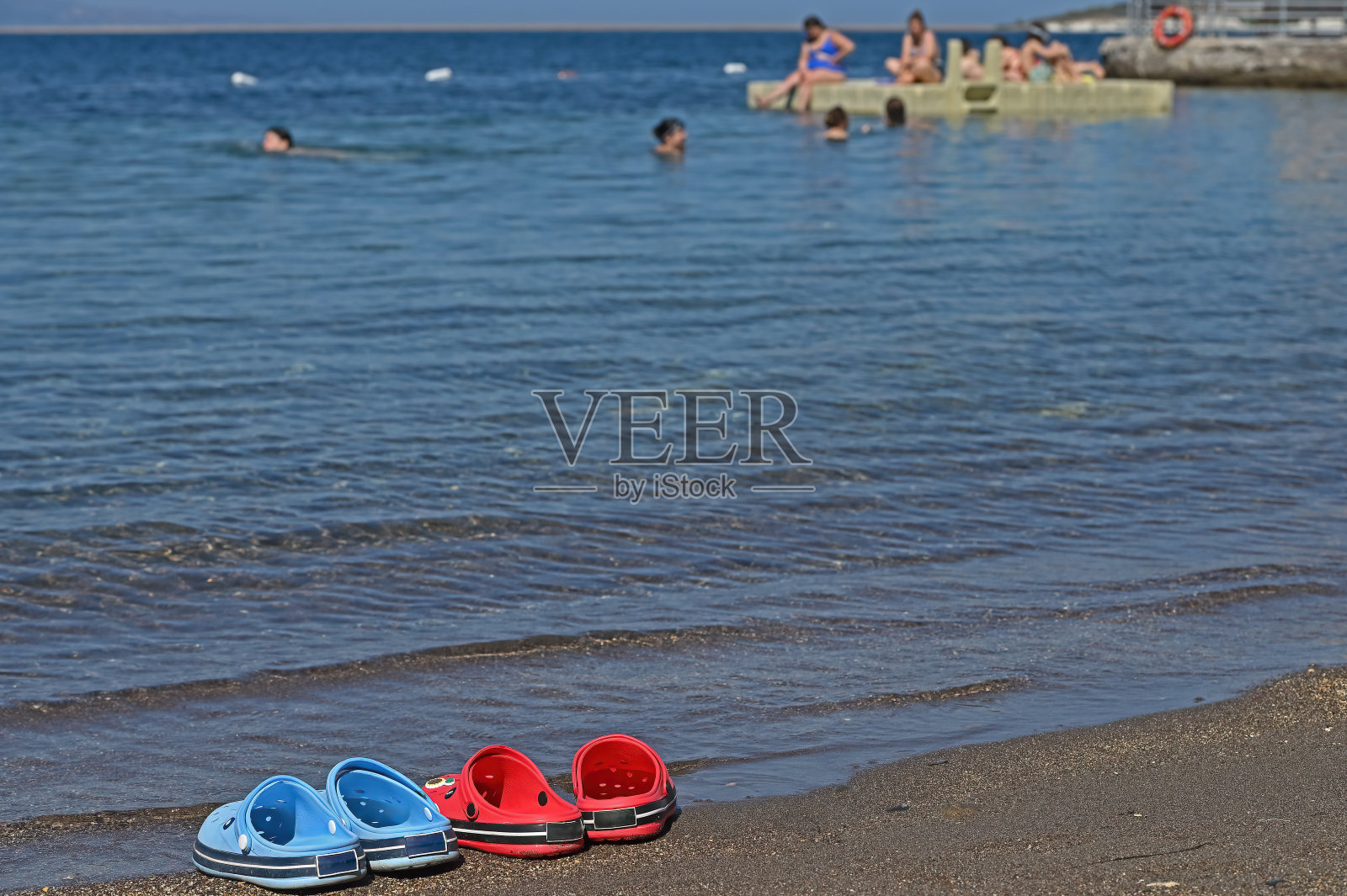 海滩上的两只红色海滩拖鞋照片摄影图片