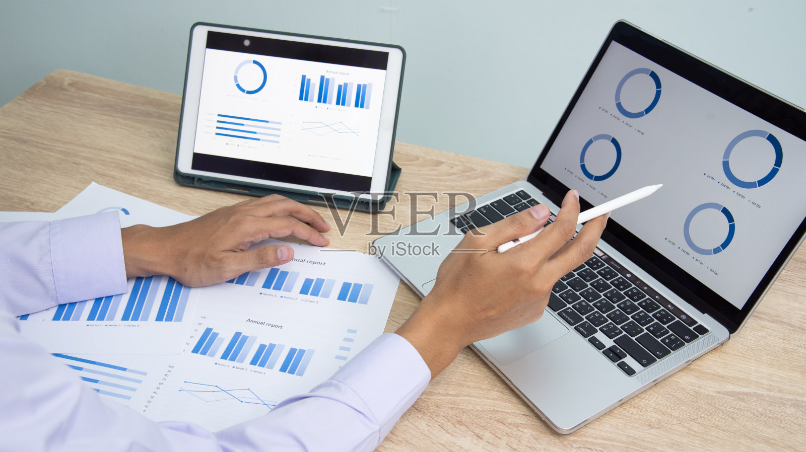 商务人士在办公室用平板电脑，笔记本电脑，智能手机工作。专业投资者在线连接互联网应用。商人审阅公司年度报告。照片摄影图片
