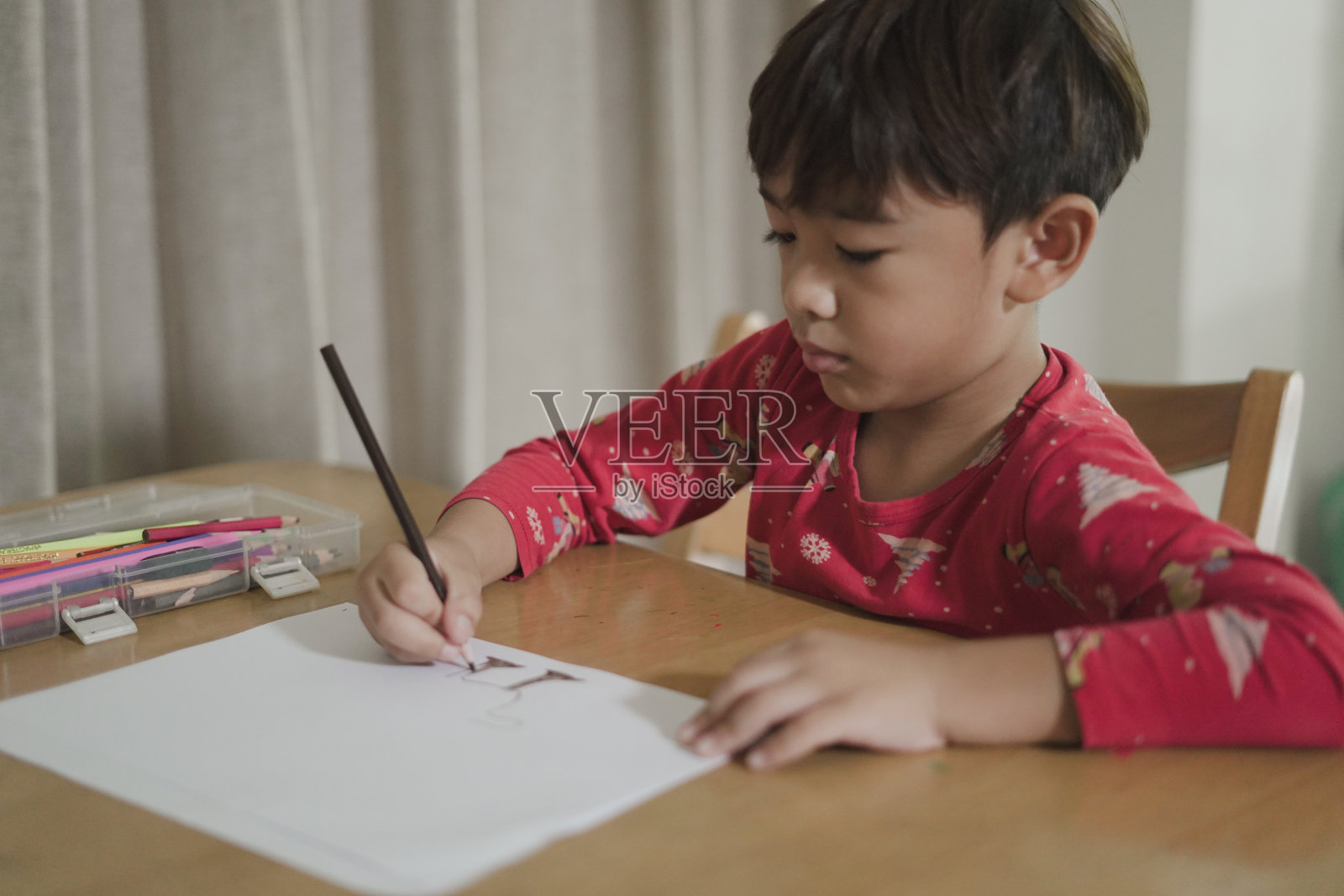 男孩在桌子上画画玩得很开心照片摄影图片