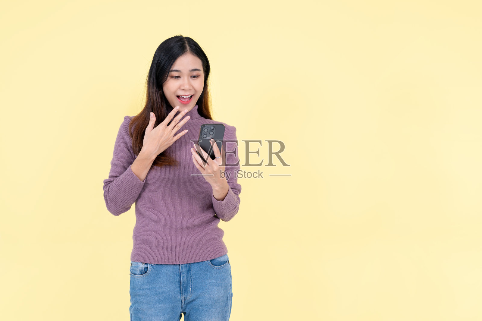 一位美丽的亚洲女性正带着震惊和惊讶的表情看着她的智能手机屏幕照片摄影图片